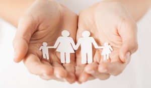 close up of womans cupped hands showing paper man family