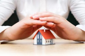 house covered of woman hands - insurance real estate concept